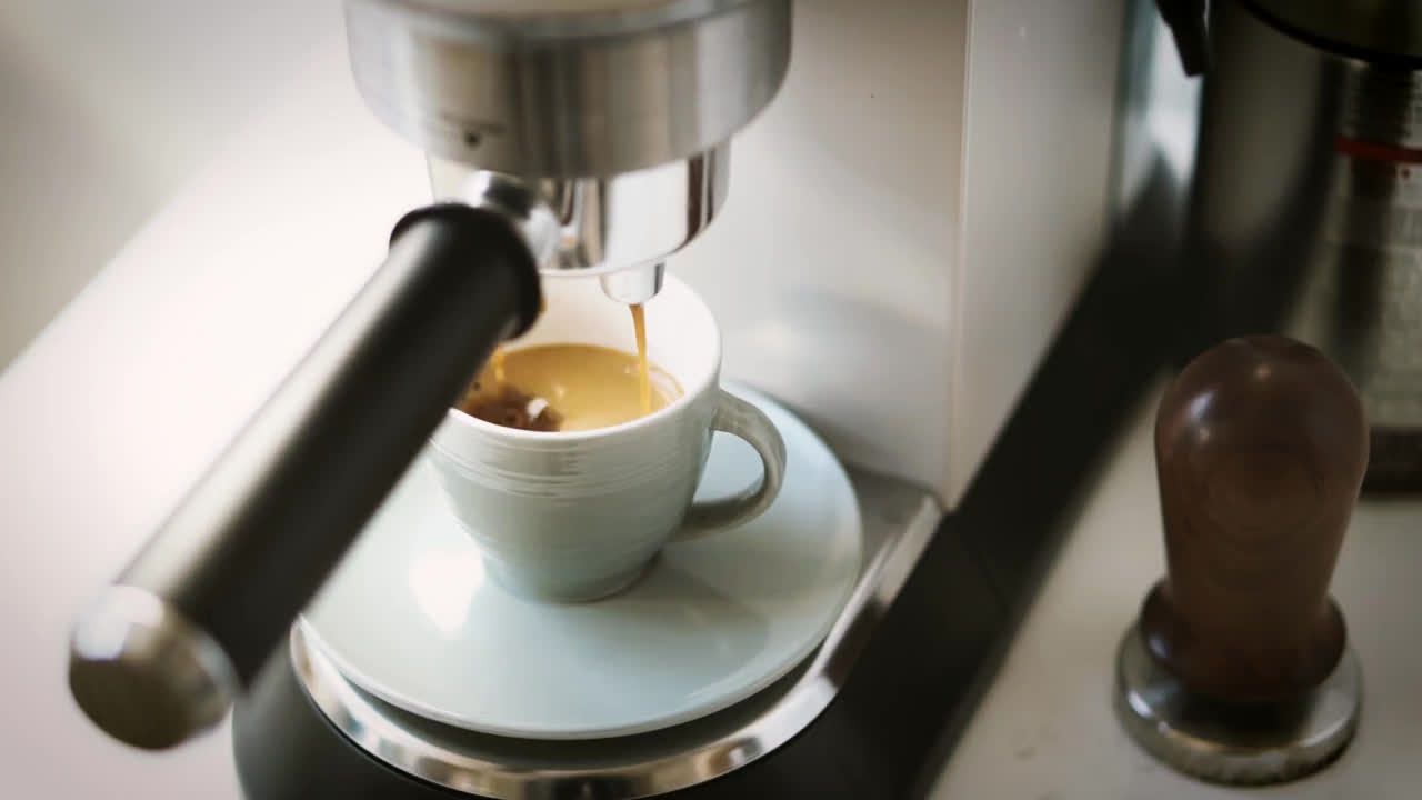 Espresso fließt in eine Tasse – Symbolaufnahme